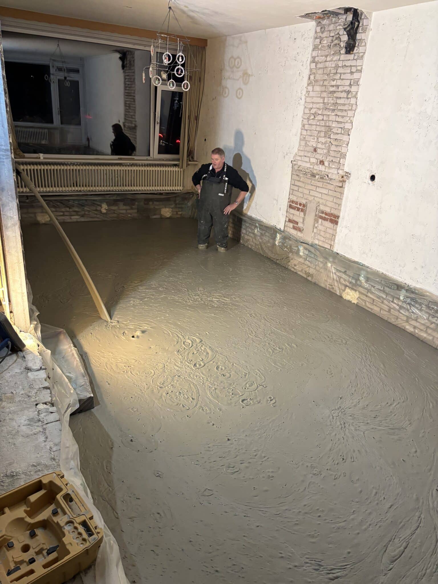 Een naadloos gestorte schuimbetonvloer die doorloopt van de woonkamer naar de keuken in Ermelo.